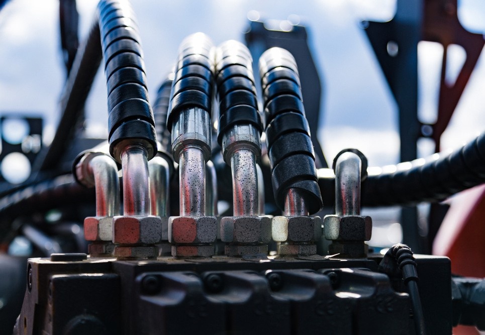 Close-up view of industrial hydraulic hoses connected to heavy equipment.